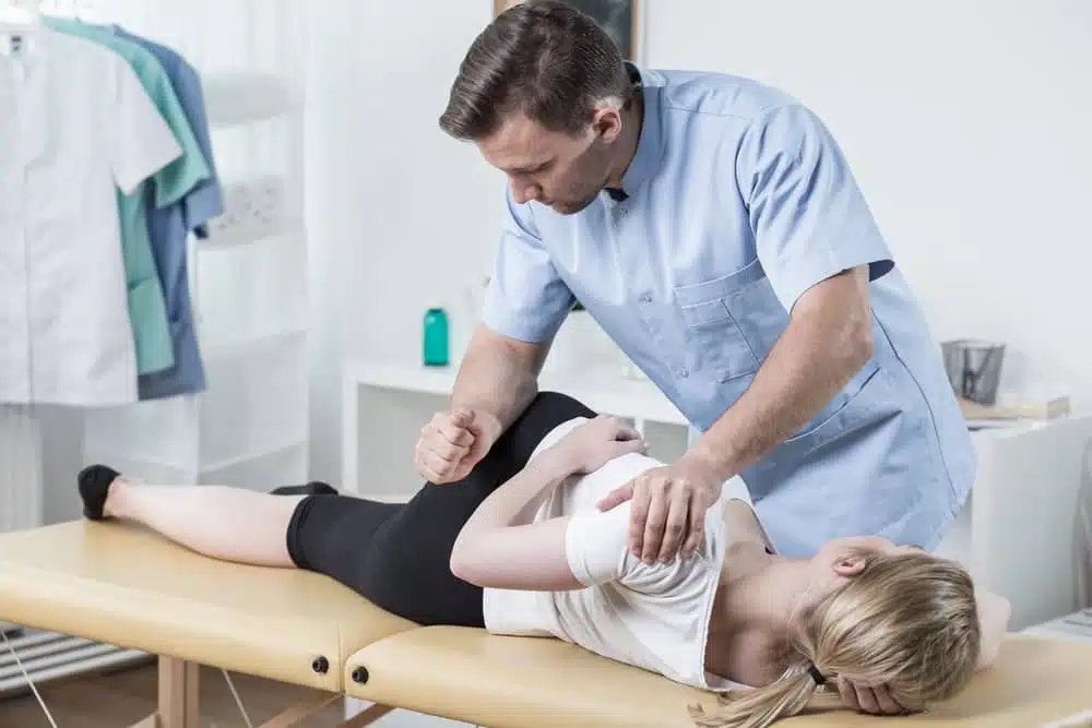 femal patient having adjustments from a male chiropractor for Piriformis Syndrome treatment