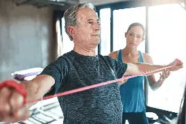 An elderly man experiencing back pain while exercising