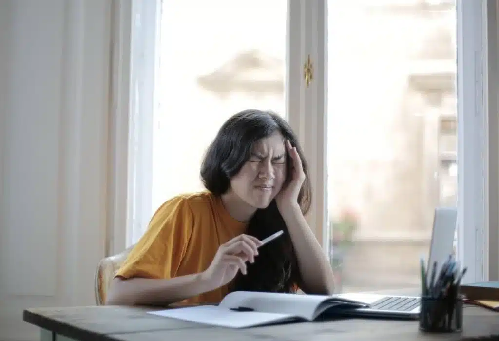 girl having a headache while studying