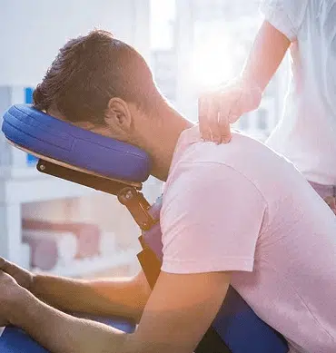 A man receiving a massage on the back of the neck