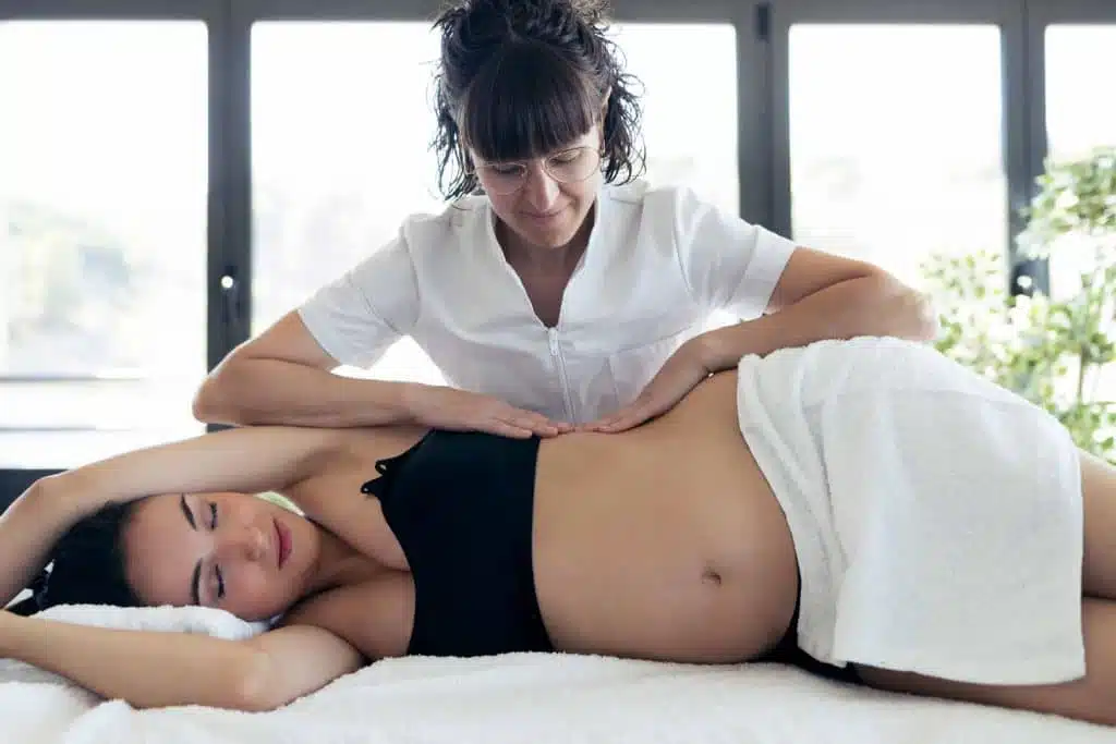 Prenatal chiropractor giving a pregnant woman care treatment