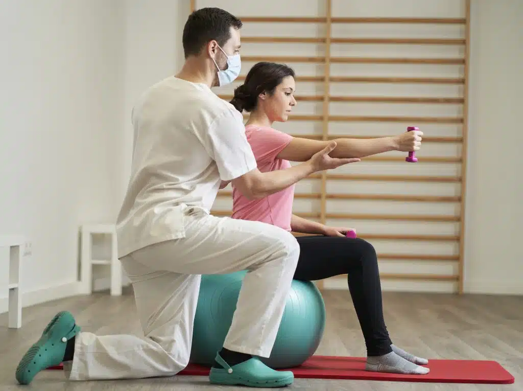 The physiotherapist doing rehabilitation exercises with the patient