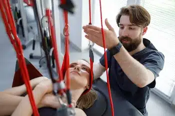 physiotherapist kneads the neck of a woman during rehab