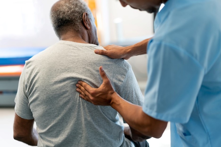 Male therapist massaging a senior's man back during physiotherapy